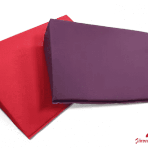 Ein rotes und ein violettes Keilkissen. Dieses wird als Positionierungshilfe in der Pflege eingesetzt.